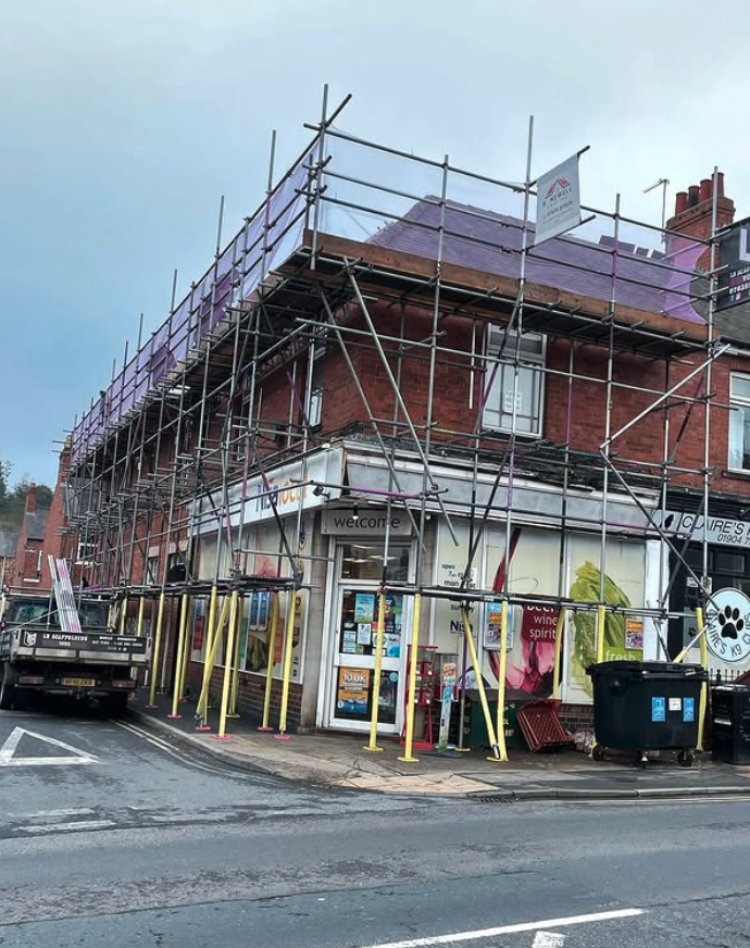 Corner shop scaffolding with safety sheeting on a York high street