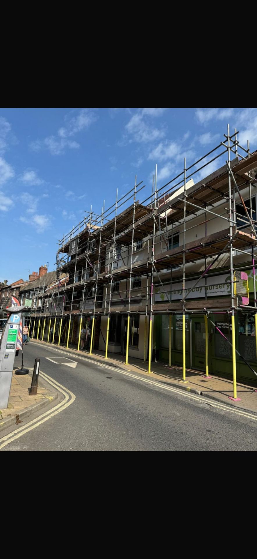 York high-street commercial property with multi-lift scaffolding and yellow leg protectors