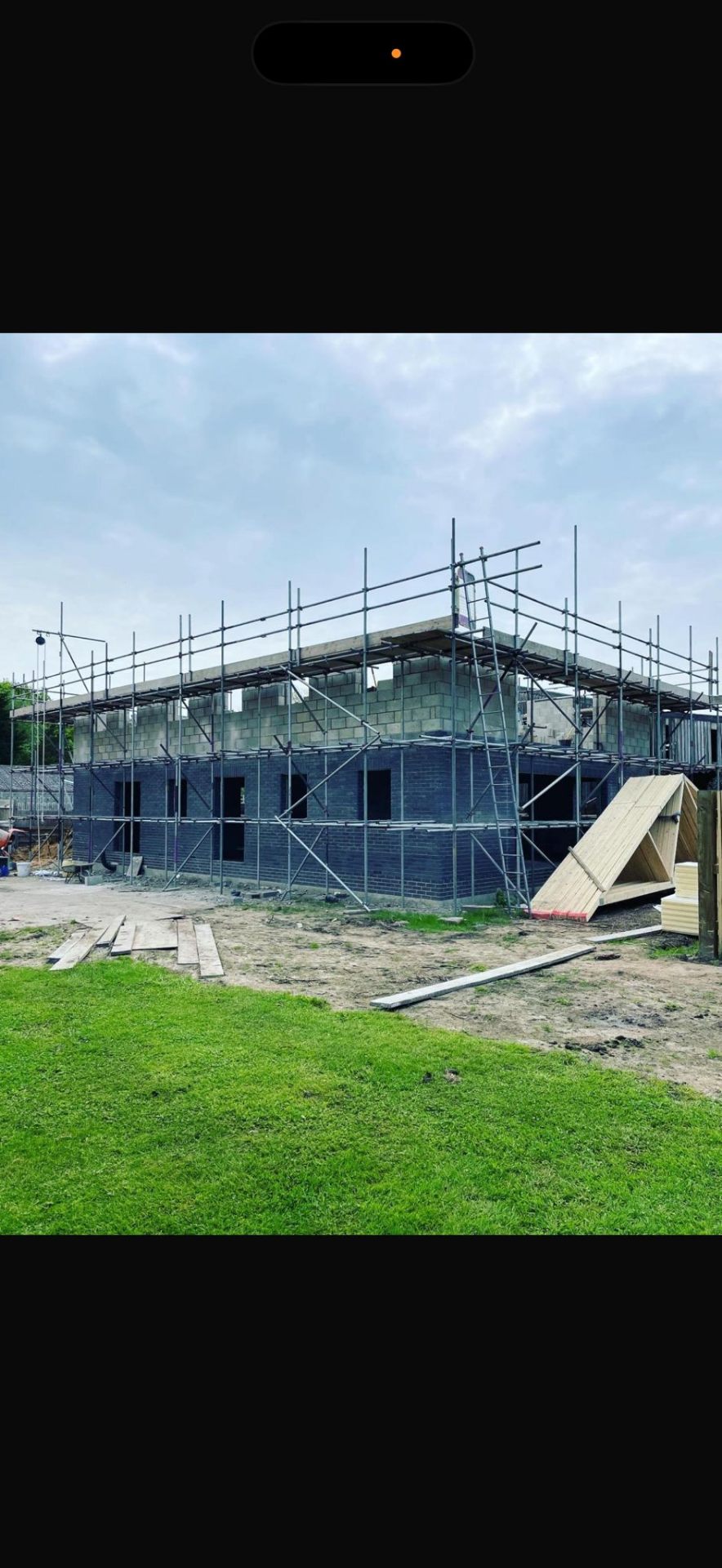 New build dwelling with scaffolding wrapped around blockwork at first-floor level