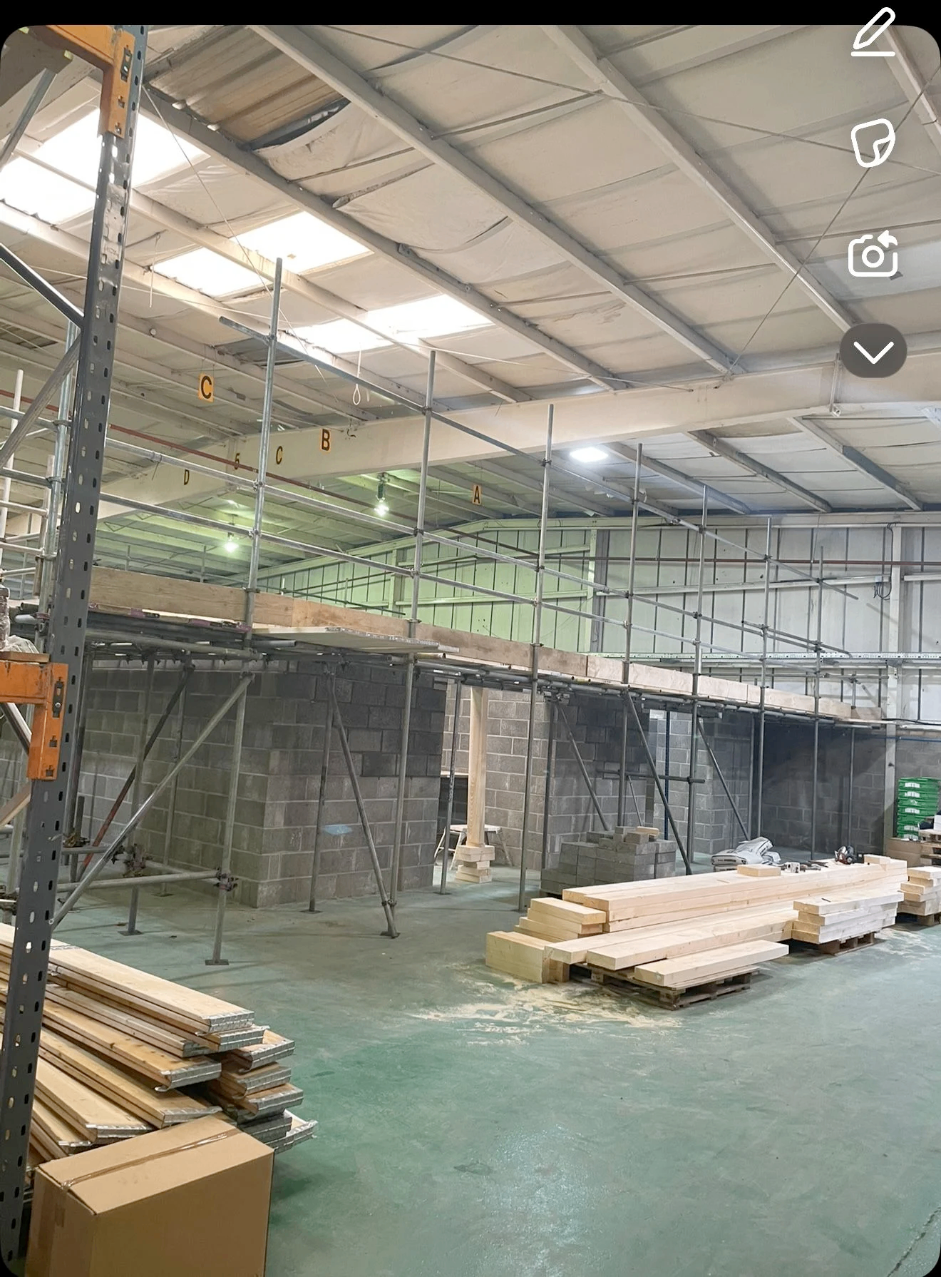 Inside the LB Scaffolding Ltd yard with stacked timber boards and racks of scaffold tube