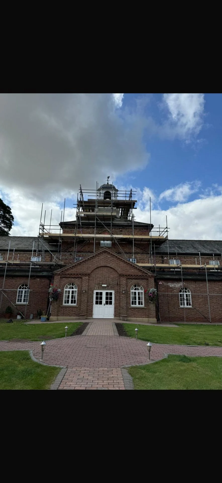 Heritage stable block with cupola surrounded by scaffolding for restoration works